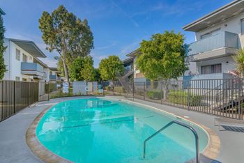 a swimming pool in front of an apartment building with a pool at BLVD Apartments LLC, Tarzana, CA